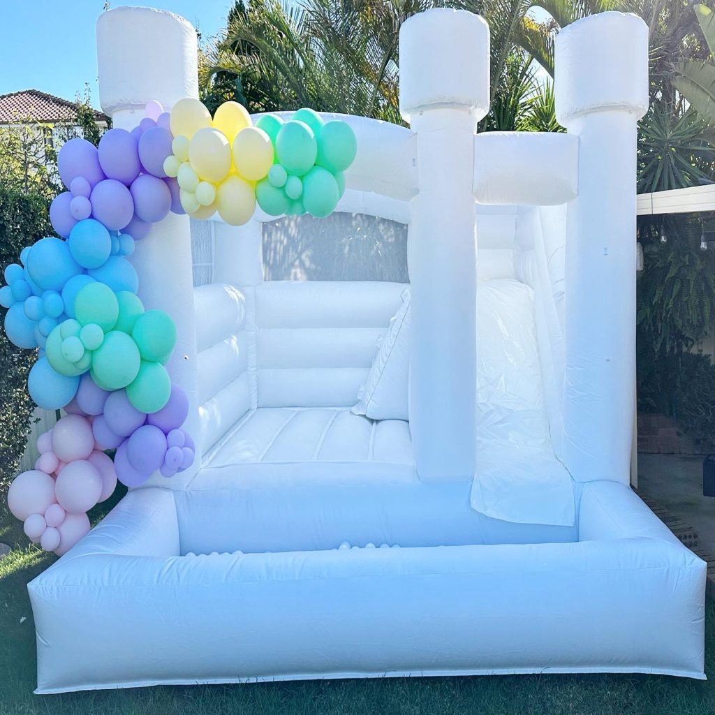 White jumping castle with a slide and ball pit